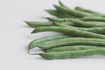 Bunch of raw green beans on white table, selective focus