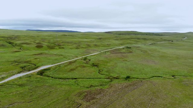 The infinite green fields in the Scottish Highlands - aerial drone flight
