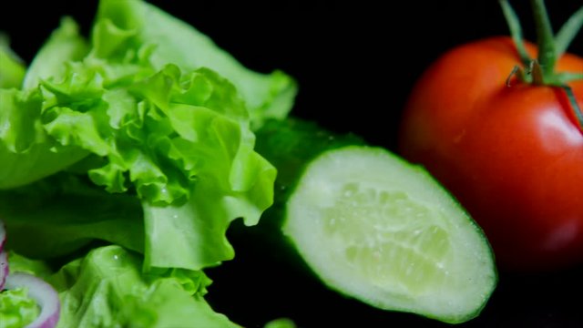 Close up of fresh vegetables and tasty burger with cheese and beef cutlets on the black background