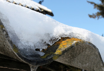 Slate roofs with icicles covered with snow, covered with snow,