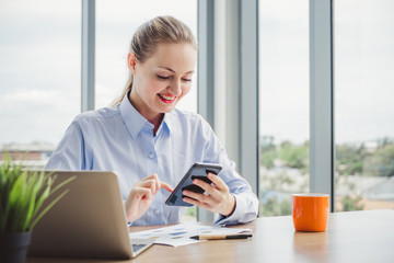 Young beautifulbusiness woman talking on the phone and working on table in a modern office