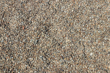 Texture for the background from small gray pebbles of river pebbles. A background for design and creative work. Decoration and exterior decoration of the building. Construction works. Stones for beach