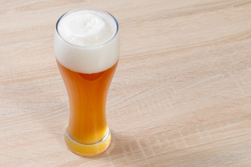 Top view on a fresh wheat beer on a wooden table in the brewery