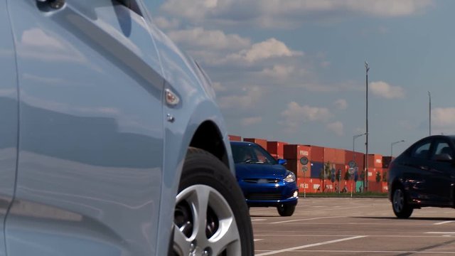New cars, lined up, leave the parking lot of the car factory, directs to meet with the customer