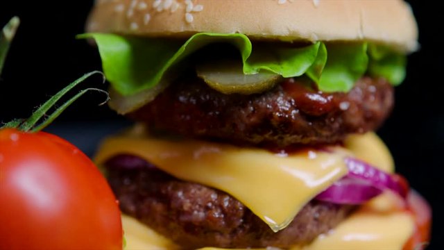 Close up of burger bun with sesame, greens, cheese and beef for commercial use