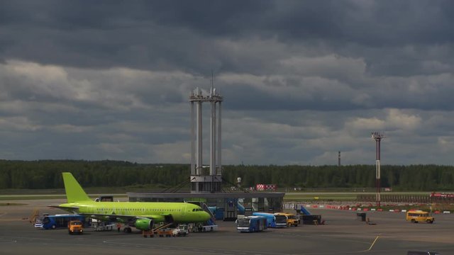 The planes are standing at the airport waiting for their turn to take off. Around the cars of technical airport services