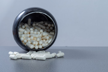 White pills in front of an open box with several white pills in it