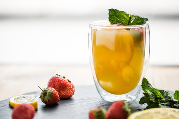 close-up view of glass with juicy summer cocktail with mint and strawberries
