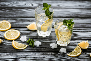 white rum.high angle view of glasses with mojito cocktail and ingredients on wooden table.high angle view of glasses with mojito cocktail and ingredients on wooden table.high angle view of glasses wit