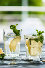 two glasses with fresh cold mojito cocktail on table
