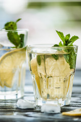 close-up view of two glasses with fresh cold mojito cocktail on table