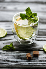high angle view of glass with fresh cold mojito cocktail on wooden table