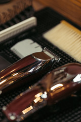 close-up view of electric clippers and various hair combs in barbershop