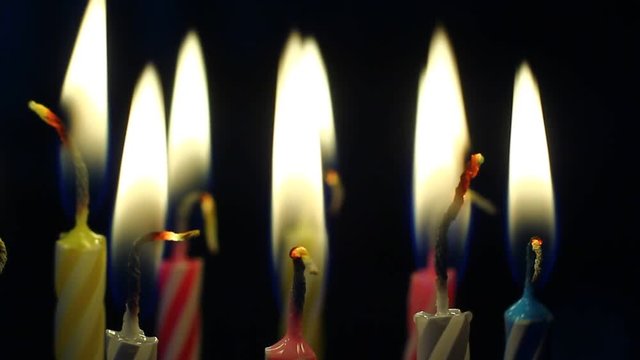 Macro of various colorful birthday candles slowly burning down.