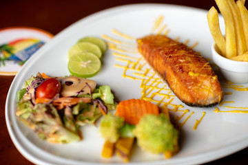 Fried salmon steak fish, chips and vegetables