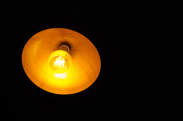 Light bulb illuminated and taken from above and isolated against black