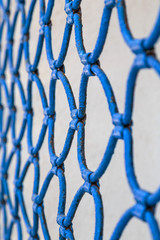 blue lattice fence on light background of plaster wall