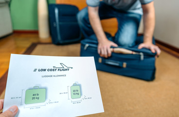 Man trying to close full hand luggage for comply low cost airlines restrictions