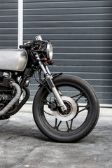 Obraz premium Vintage motorcycle parking near industrial building. Everything is ready for having fun driving the empty road on a motorcycle tour journey. Brutal man hobby. Space for your individual text.