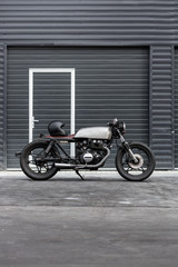 Custom caferacer parking near industrial building. Everything is ready for having fun driving the empty road on a motorcycle tour journey. Hipster city hobby. Space for your individual text. - 214188476