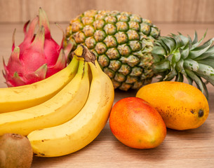 Tropical fresh fruit set and juice smoothies isolated with wooden background