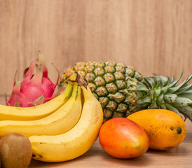 Tropical fresh fruit set and juice smoothies isolated with wooden background