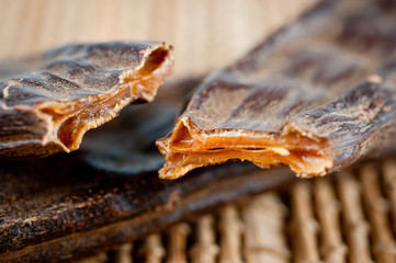 Fruits and carob seeds taken close-up against the background of a bamboo mat