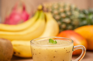 Tropical fresh fruit set and juice smoothies isolated with wooden background