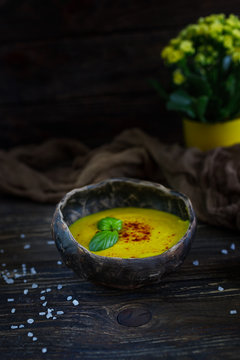 Homemade corn cream soup with smoked paprika on a dark wooden background