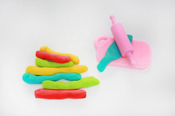 Colorful dough and rolling pin on white background for kid play to develop EQ and IQ.
