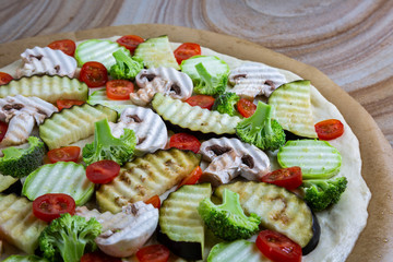 Homemade pizza with vegetables, natural dough on leaven. With zucchini, eggplant, cherry tomato, broccoli, mushrooms. The concept of a healthy diet. Vegetarian.