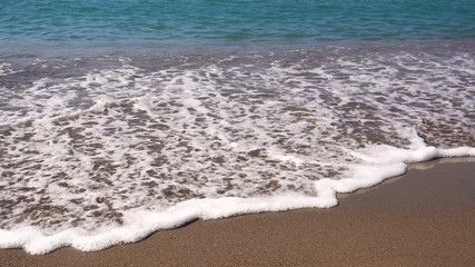 Sea surf on a sandy beach.