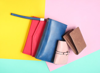 Many leather purses on a colored pastel background. Top View.