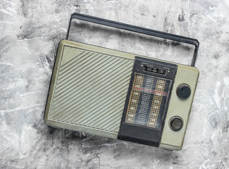 Retro old radio receiver on a gray concrete background. Top view. Outdated technology.