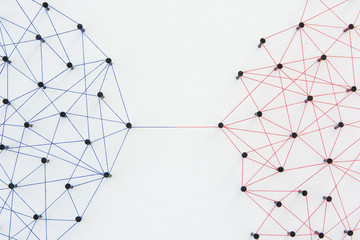 Connecting networks concept - two network connected with yarn red and blue on white paper....