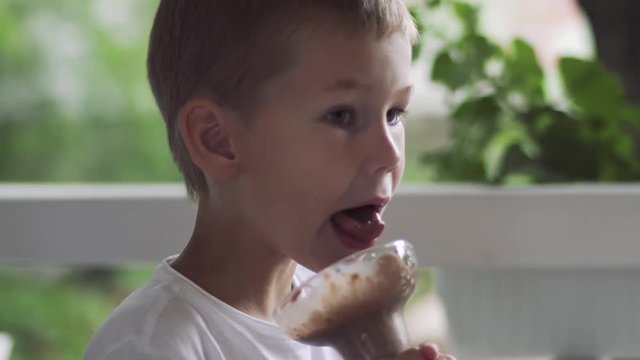 Boy licking ice cream in glass