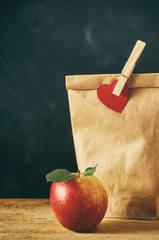 Close up on red apple and brown bag lunch