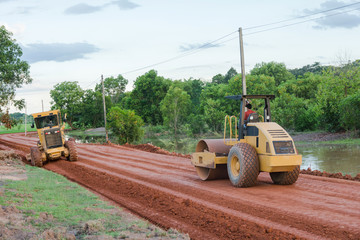 Roller steamroller or vibratory roller machine and motor graderworking on road construction site of...