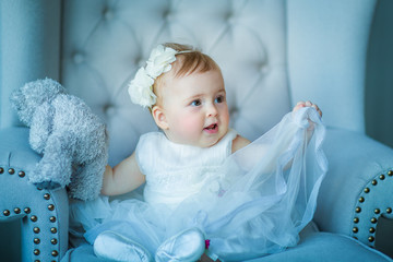 Image of sweet baby girl in a wreath, closeup portrait of cute 8 month-old smiling girl,  toddler.Studio shooting
