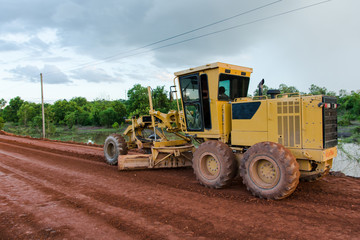 Yellow motor grader Road working on road construction site of new road.