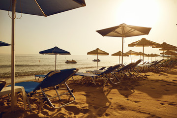 Beach in the resort in the summer. Umbrellas and chaise lounges on the sand of the summer beach.