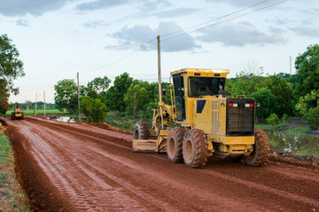 Yellow motor grader Road working on road construction site of new road.
