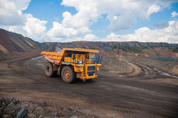 Obraz premium The mining dump truck transports ore and other minerals in the quarry. Colorful quarry