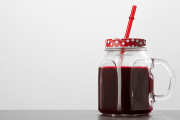 red juice in glass jar on white background