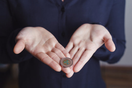 Woman's hand holding ripple coin