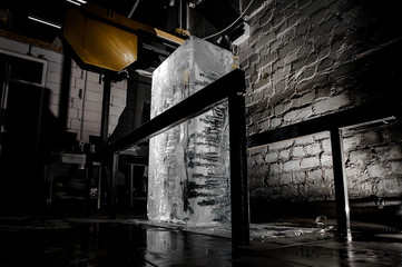 Big ice cube standing on the floor on the ice production plant