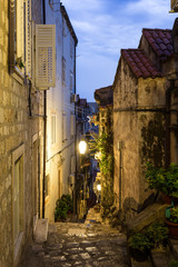 The atmospheric very narrow medieval street inside Dubrovnik old town at sunset in Croatia, Eastern Europe