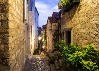 The atmospheric very narrow medieval street inside Dubrovnik old town at sunset in Croatia, Eastern Europe