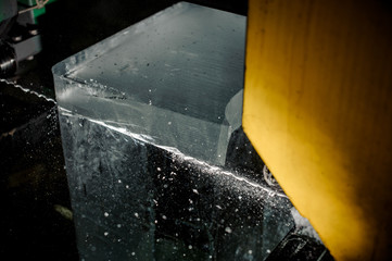 Cutting a big ice cube with a special tool on the plant