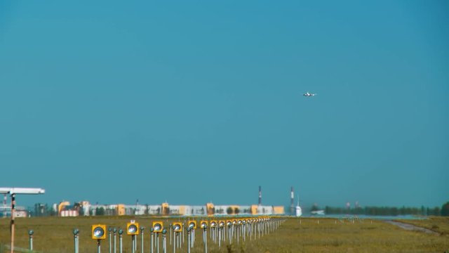 Runway with an airplane taking off and simultaneously the board preparing to landing on this band. View through the hot air from the ground